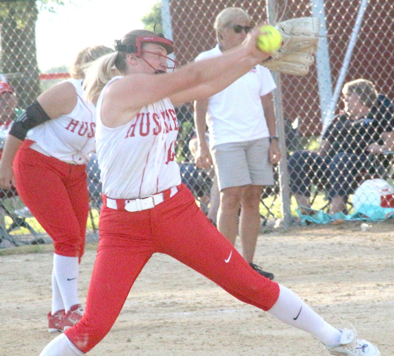 Highland’s Grace Batcheller winds up a pitch during the Huskies’ June 23 home game against Pekin.